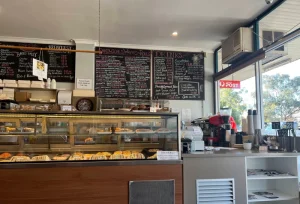 Inside Cafe D’lish showcasing menu boards, pastry display and coffee counter